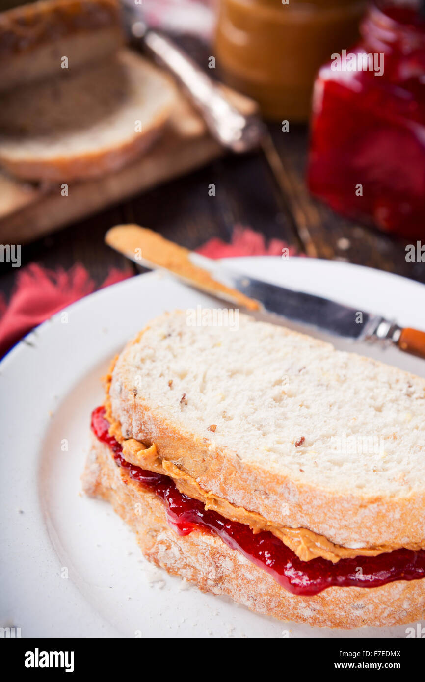 Nahaufnahme eines Erdnussbutter und Marmelade Sandwich auf einem rustikalen Tisch. Stockfoto