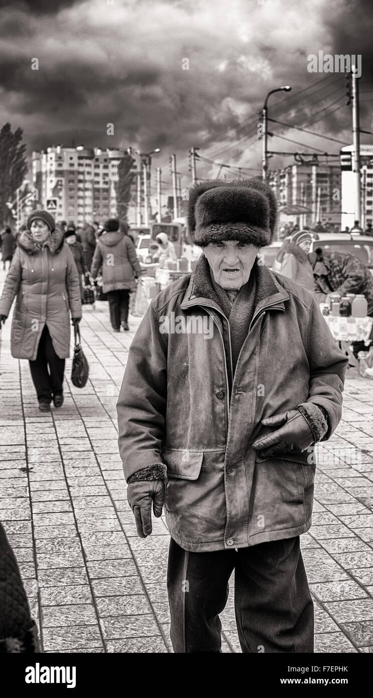 Älterer Mann trägt eine russische Pelzmütze Ushanka Bärenfell und große  industrielle Dienstprogramm Mantel Spaziergänge auf einem Fußgänger  Wanderweg Stockfotografie - Alamy