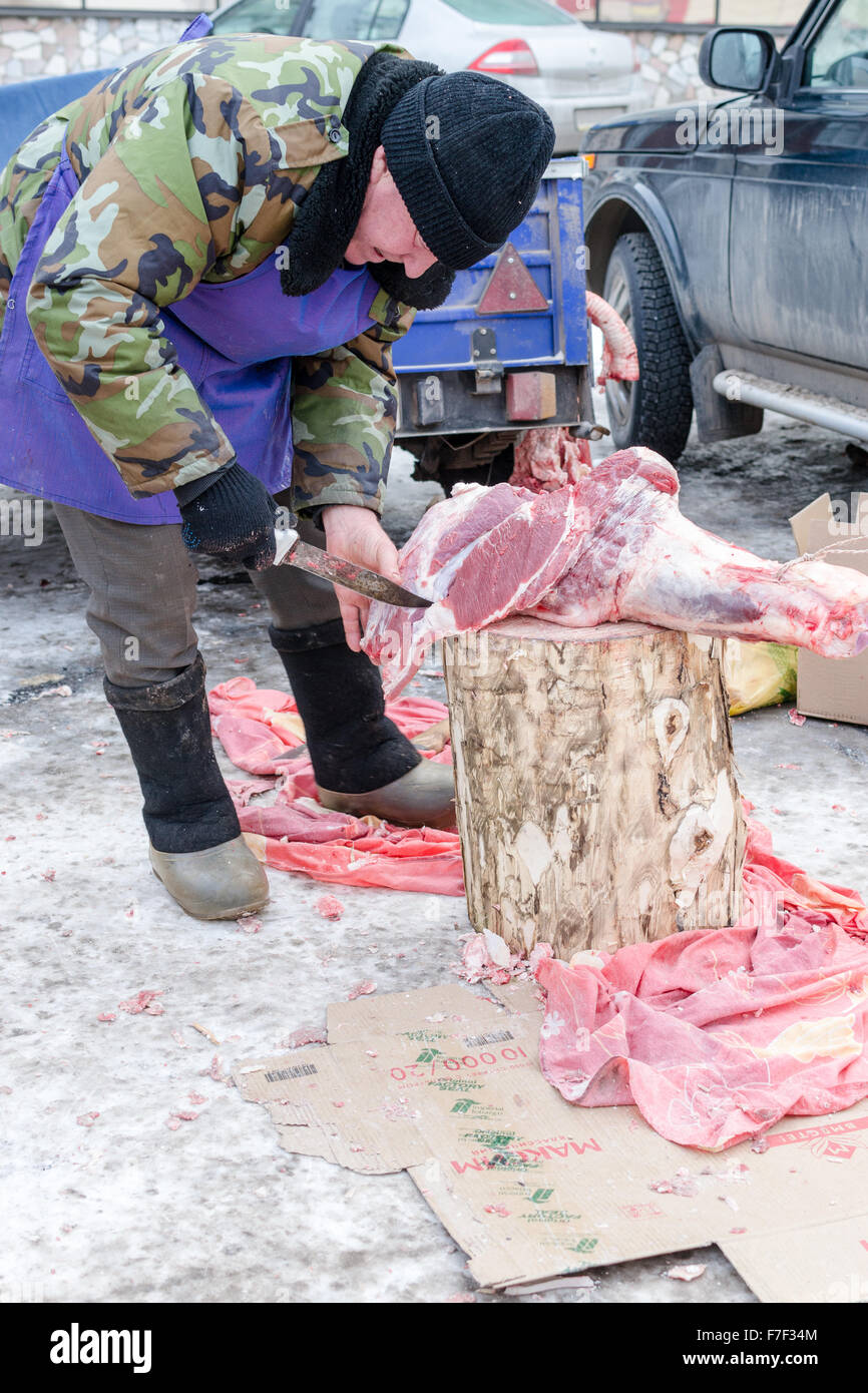 UFA, Russland - 13. November 2015: Ein Metzger bereitet frische Rindfleisch durch Schneiden und zur Zubereitung von Fleisch für den Verkauf an ein örtlicher Bauer Stockfoto