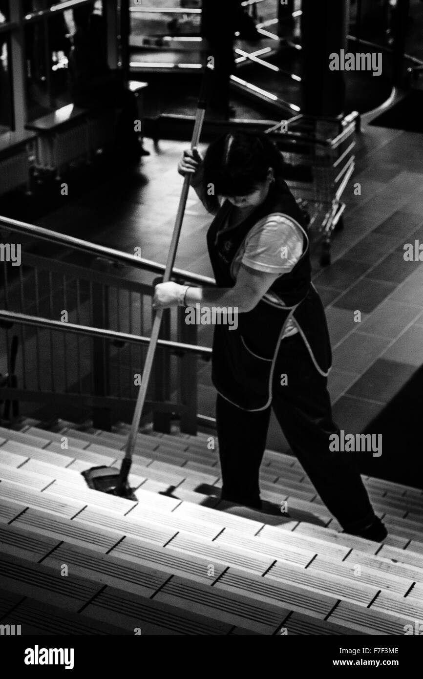 Erwerbstätige Frau Shop cleaner fegt manuell Schritte am Eingang zu dem riesigen shopping Komplex namens MEGA in Ufa, der Republik Stockfoto
