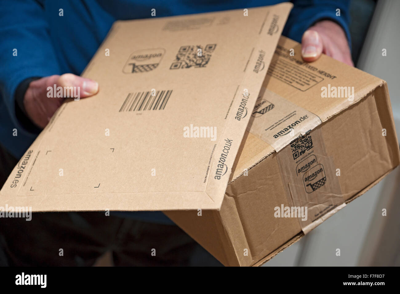 Nahaufnahme der Person Mann hält mit Amazon-Pakete Paket nach Hause  Online-Lieferung Einkaufen England Vereinigtes Königreich GB Großbritannien  Stockfotografie - Alamy