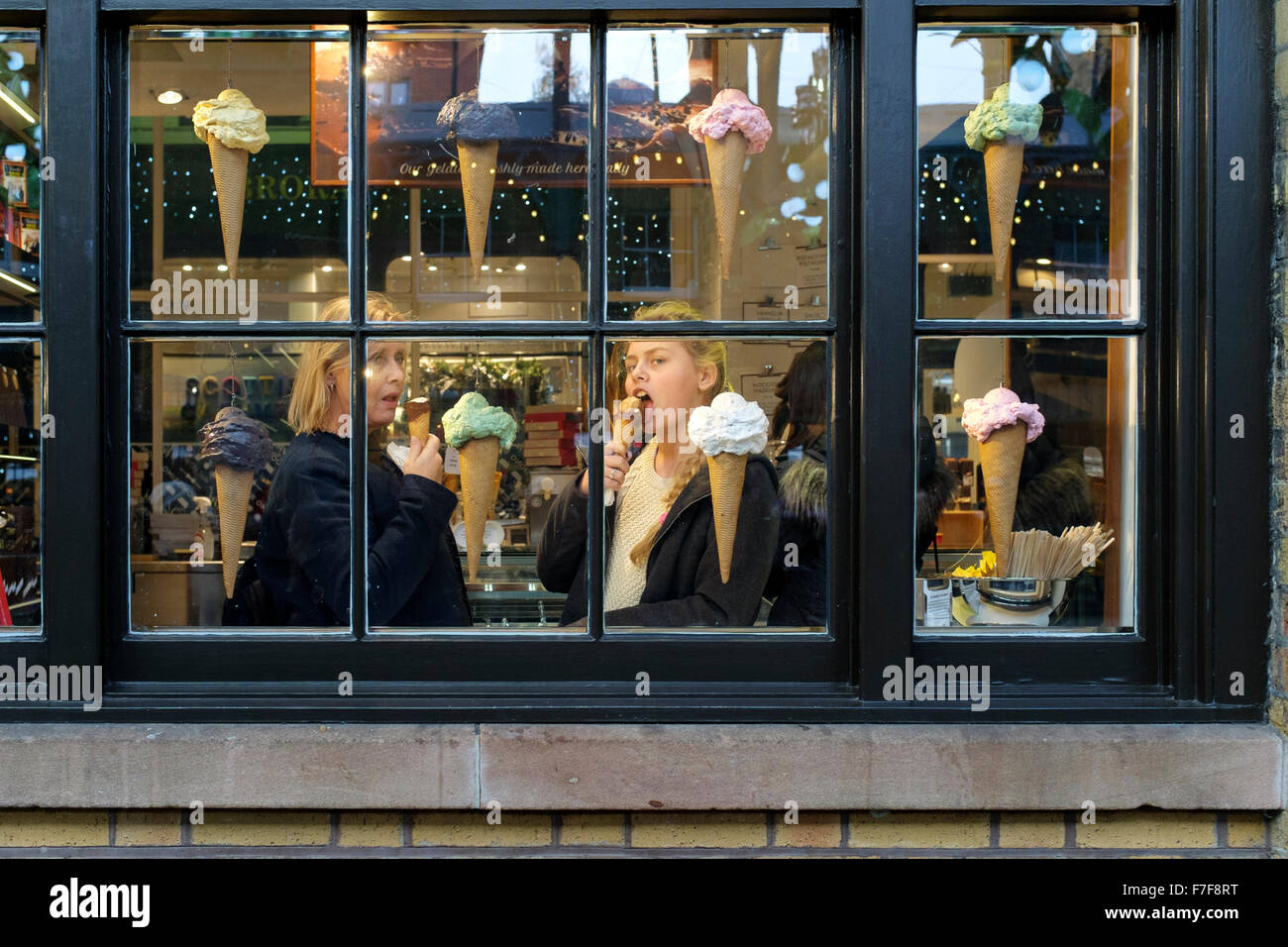Eine Frau und Mädchen essen Eis – Cream Cones in Covent Garden-Eisdiele, London UK Stockfoto