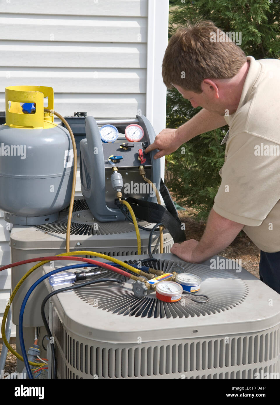 AC-Mechaniker lädt mit Freon Stockfoto