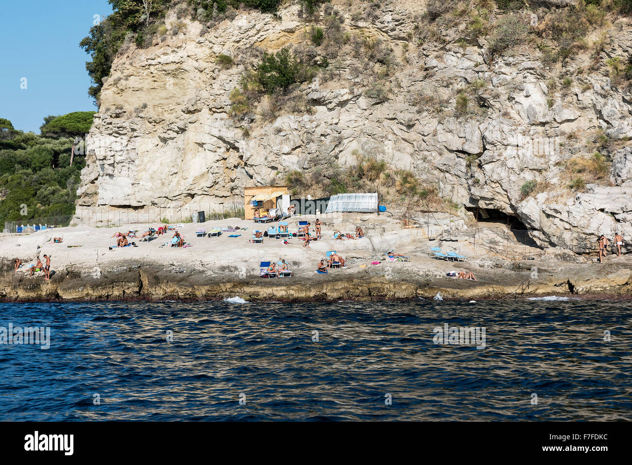 Sonnenanbeter genießen einen schroffen Felsenstrand entlang der Küste von Sorrento, Compania, Italien Stockfoto