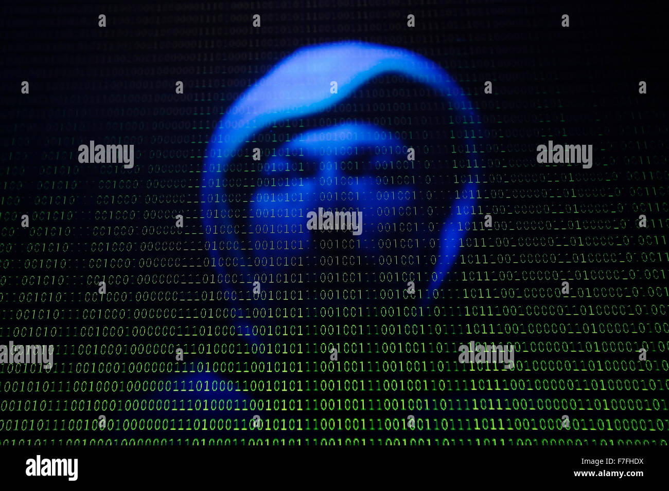 Ein Gesicht spiegelt sich in einem Computer-Bildschirm mit binären Typ Stockfoto