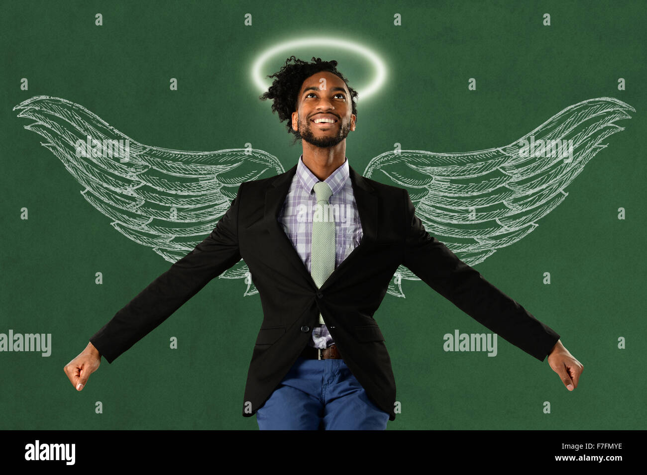Afrikanische amerikanische Geschäftsmann Held mit Flügeln und Heiligenschein über grüne Fläche Stockfoto