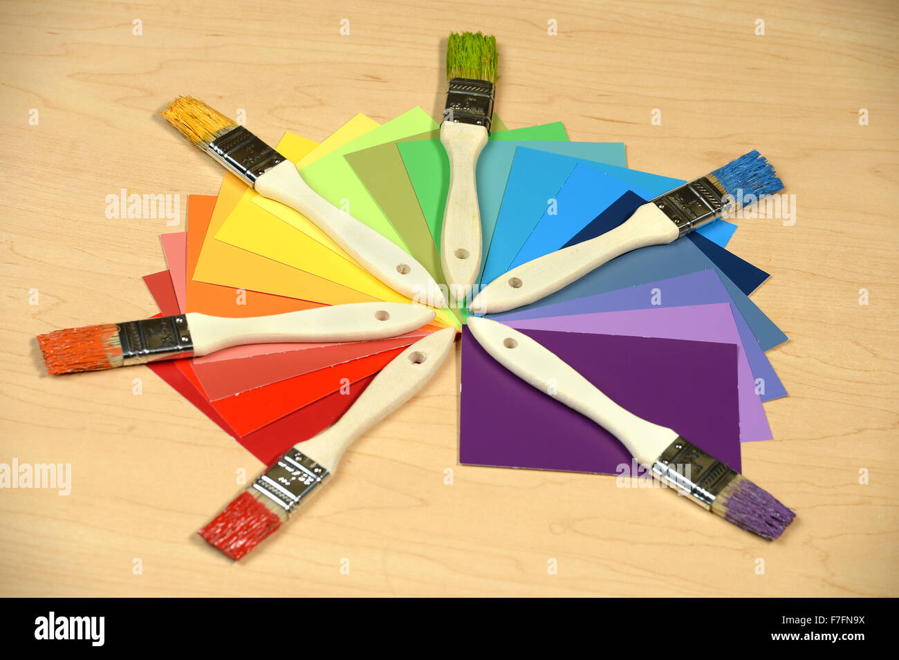 Farbmuster mit Pinsel über Holztisch Stockfoto
