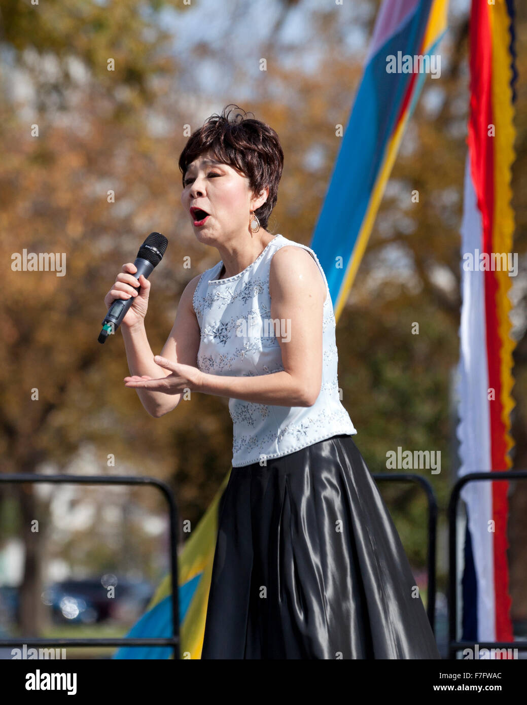 Chinesische Frau singt auf der Freilichtbühne am Kulturfestival - USA Stockfoto
