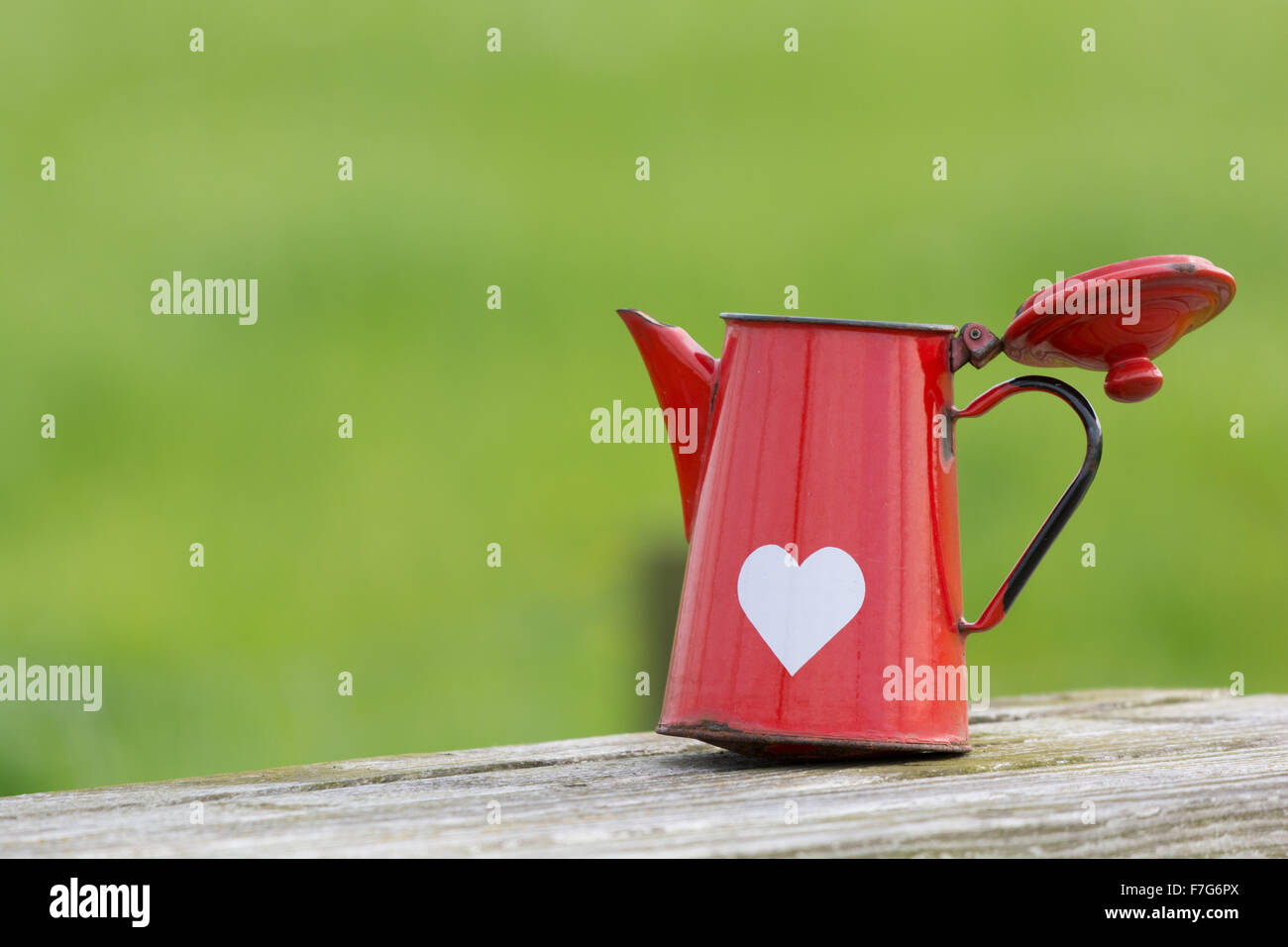 Rote Emaille Glas mit Herzform im freien Stockfoto