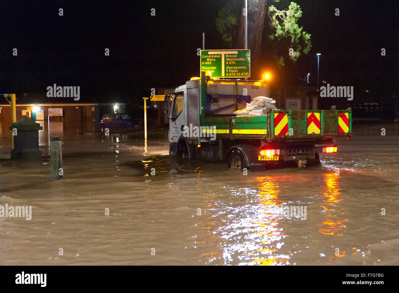 Builth Wells, Powys, Wales, UK. 30. November 2015. Des Rates Arbeiter kommen mit Sandsäcken. Teile der Mid Wales Marktstadt Builth Wells wurde überflutet späten Montagnachmittag, wenn der Fluss Wye es die Banken in der Nähe von Groe Parkplatz platzen. Bildnachweis: Graham M. Lawrence/Alamy Live-Nachrichten. Stockfoto