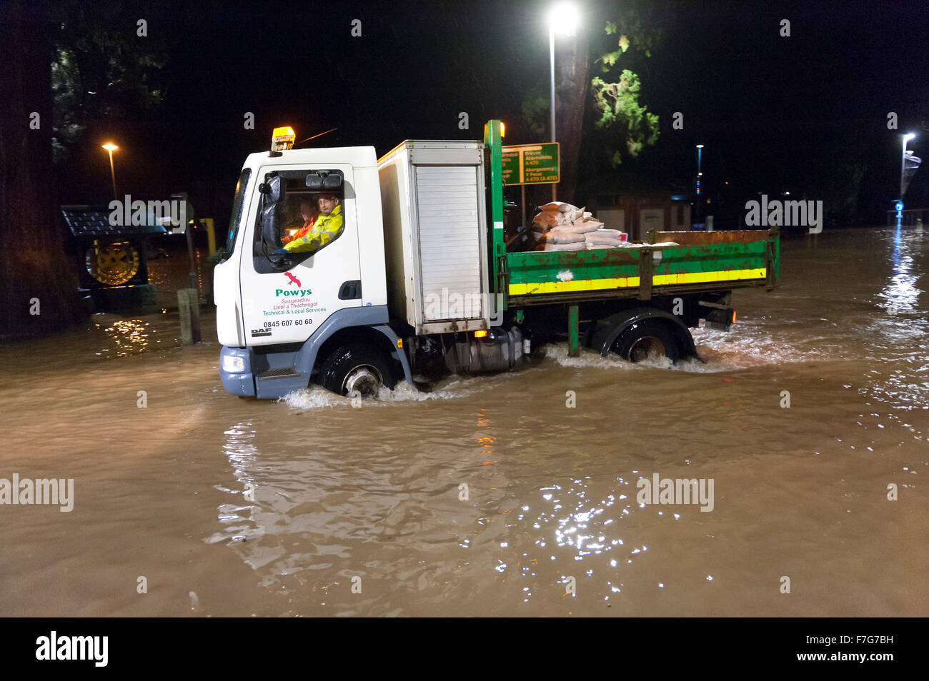 Builth Wells, Powys, Wales, UK. 30. November 2015. Des Rates Arbeiter kommen mit Sandsäcken. Teile der Mid Wales Marktstadt Builth Wells wurde überflutet späten Montagnachmittag, wenn der Fluss Wye es die Banken in der Nähe von Groe Parkplatz platzen. Bildnachweis: Graham M. Lawrence/Alamy Live-Nachrichten. Stockfoto