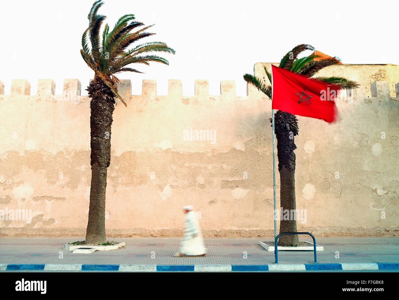 Ein marokkanischer Muslim geht zügig vorbei an der Stadtmauer auf seinem Weg zum Morgengebet. Essaouira, Marokko, Nordafrika. Stockfoto