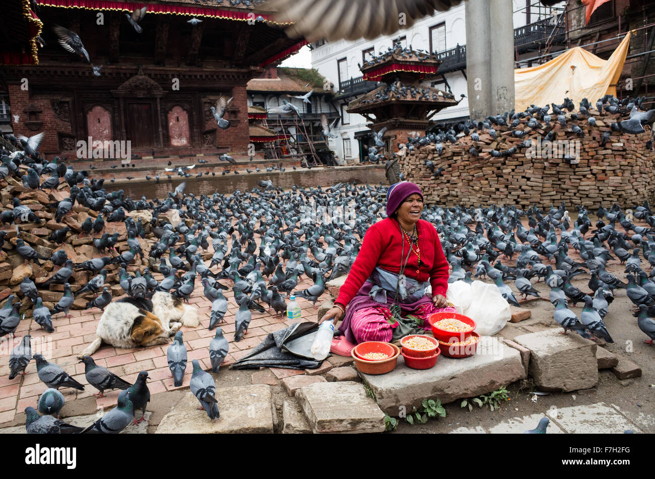 ein Mais-Getreide-Verkäuferin bei Basantapur Durbar Square mit fliegenden Tauben, Kathmandu, Nepal 2015 Stockfoto