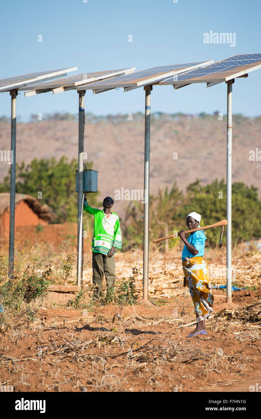 MALAWI, Dorf Zingiziwa, solar angetriebene Wasserpumpe für Bewässerung und Wasserversorgung im Dorf, Frau mit Hacke Stockfoto