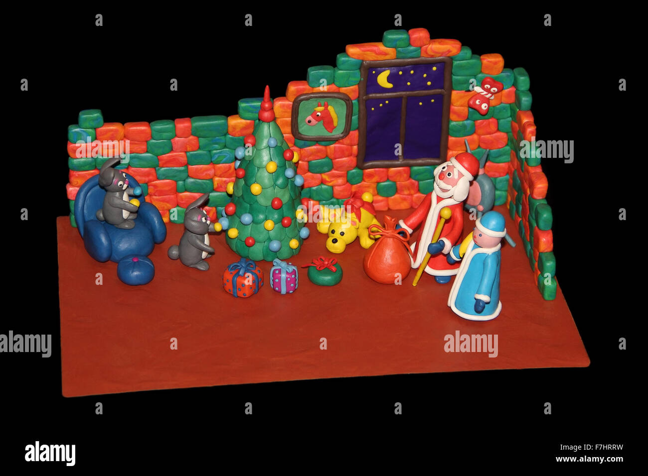 Plastilin Kaninchen schmücken einen Weihnachtsbaum für die Ankunft des Weihnachtsmannes Stockfoto