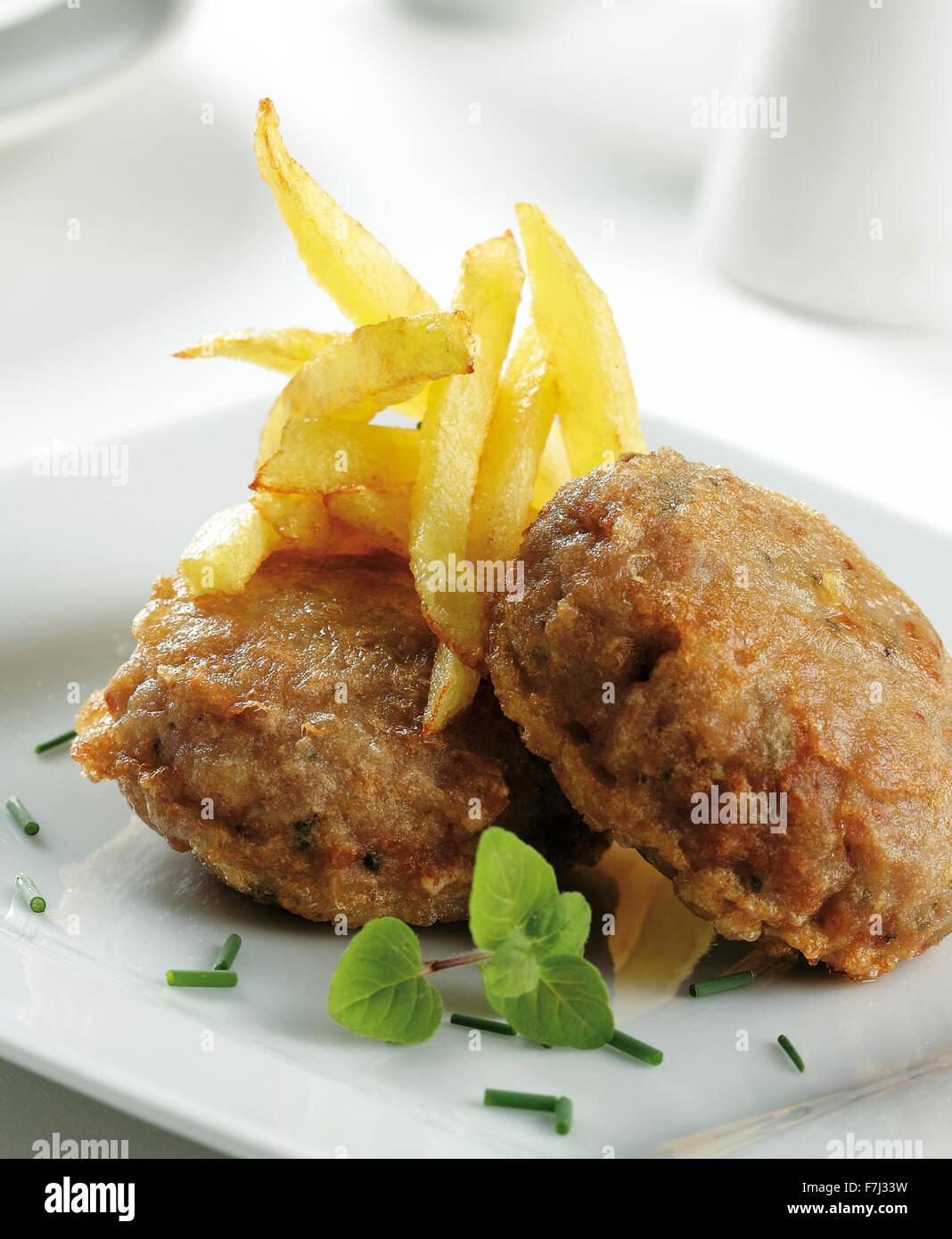 Leckere Burger in Teig, gebraten, serviert mit französischen gebratenen Kartoffeln Stockfoto