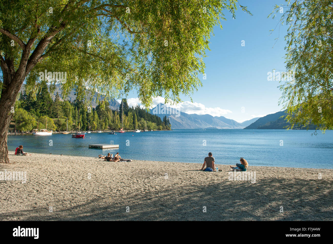 Touristen entspannen Sie am Ufer des Lake Wakatipu in Queenstown, Neuseeland. Stockfoto