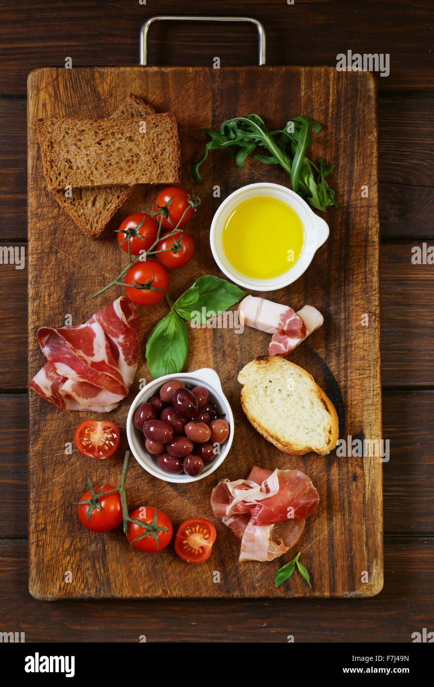 Italienische Küche-Stillleben - Schinken, Oliven, Tomaten, Basilikum Stockfoto