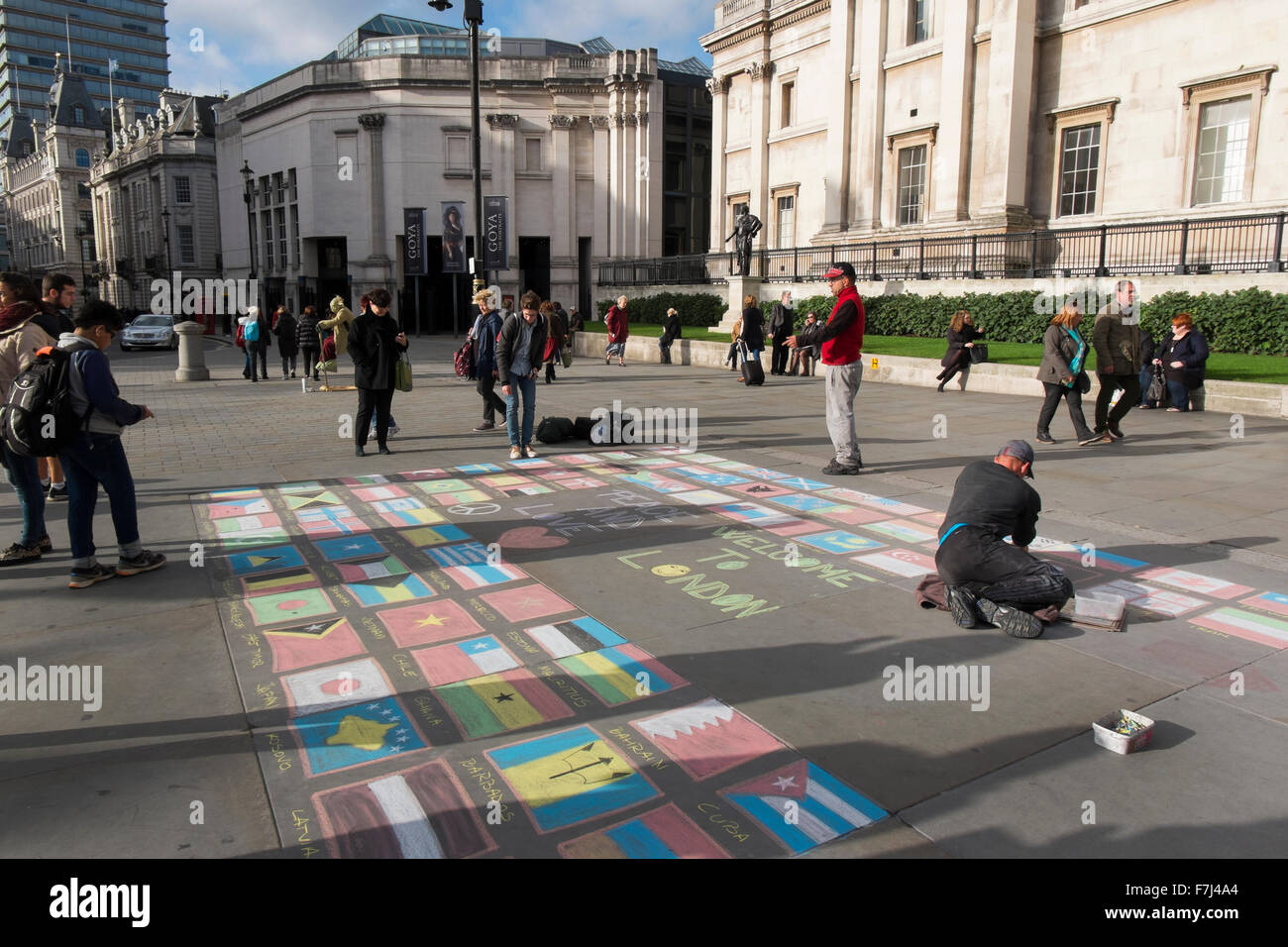Street Performer Zeichnung die Flaggen der Welt mit Kreide auf dem Bürgersteig vor der National Gallery, London, Großbritannien Stockfoto