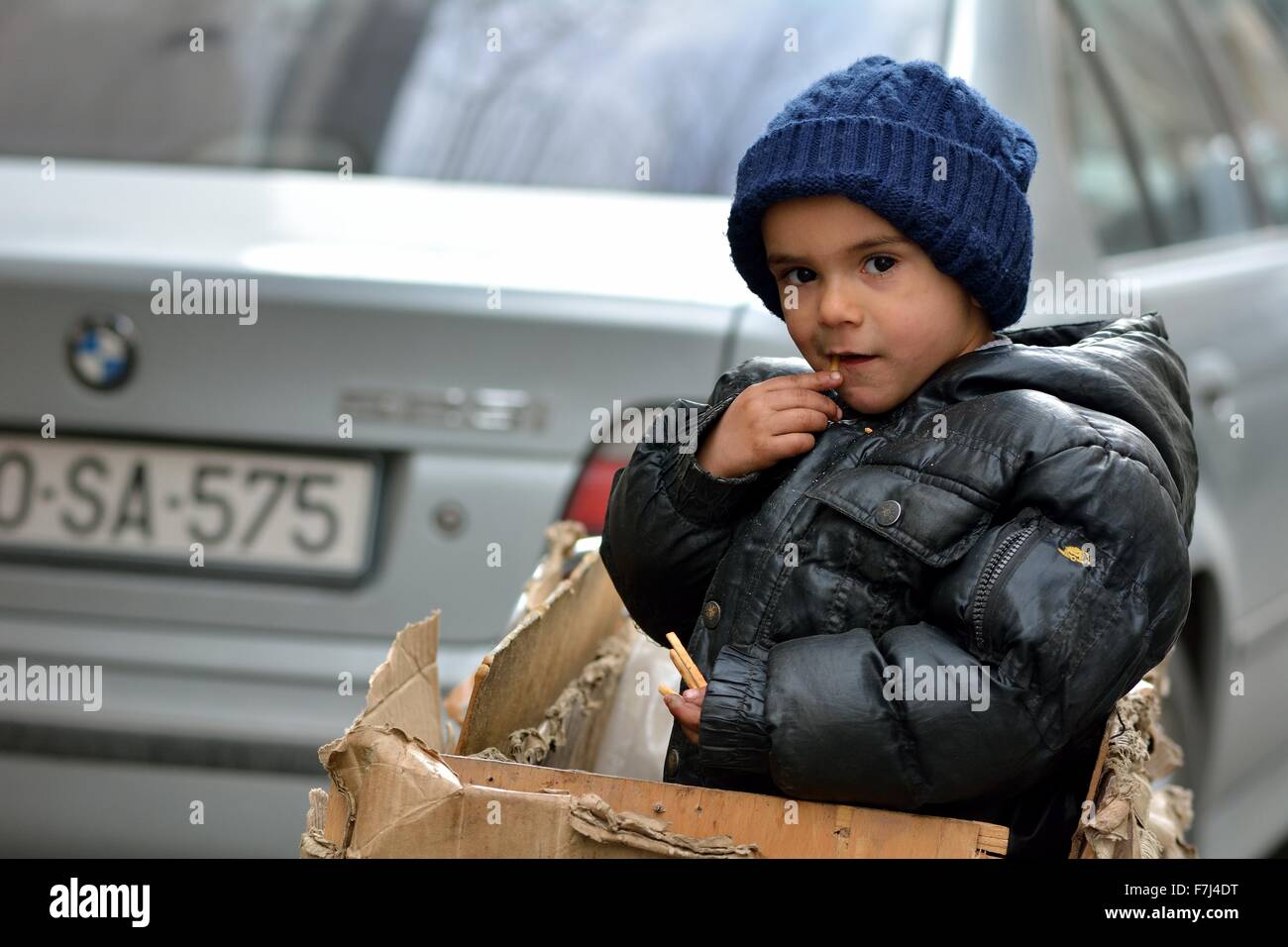 BAKU, Aserbaidschan - 24 Januar 2014 junge im Feld an Vaters Hand zog Trolley als Vater transportiert sammelt recycling zu verkaufen Stockfoto