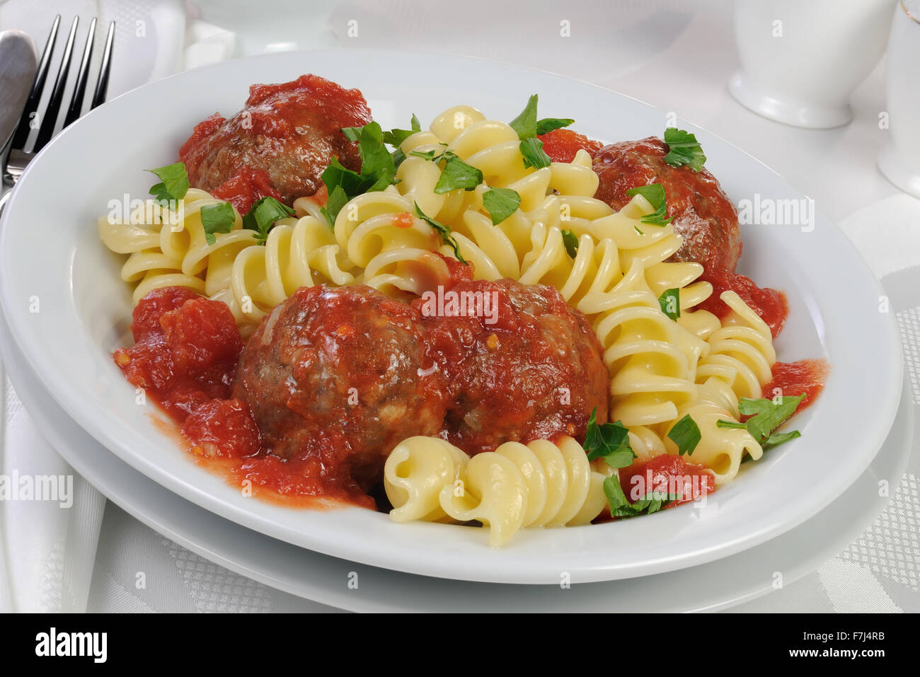 Pasta mit Hackfleischbällchen in Tomatensauce und Kräutern Stockfoto