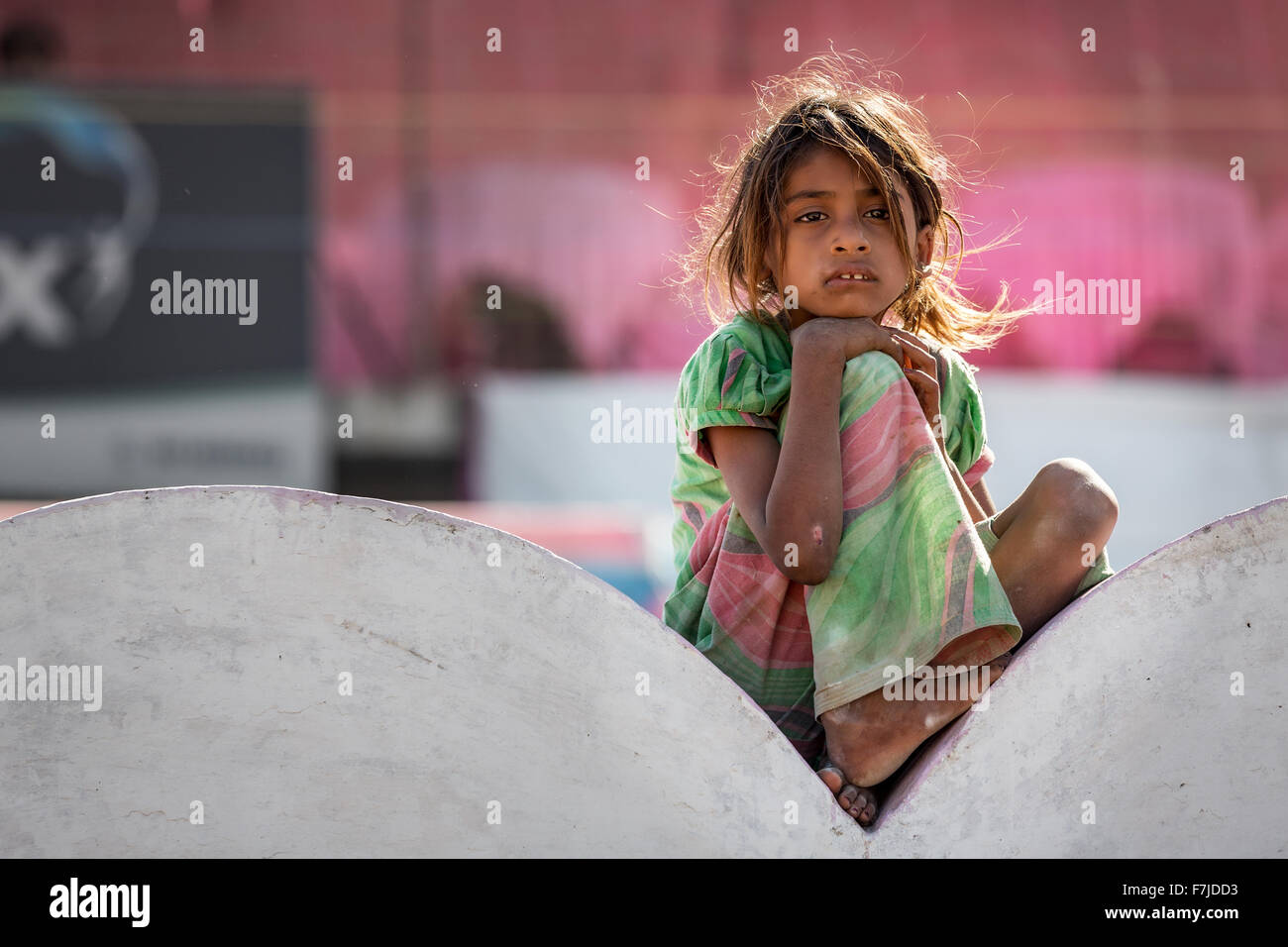 Armes Mädchen sitzt auf einer Mauer, Porträt, Pushkar, Rajasthan, Indien Stockfoto