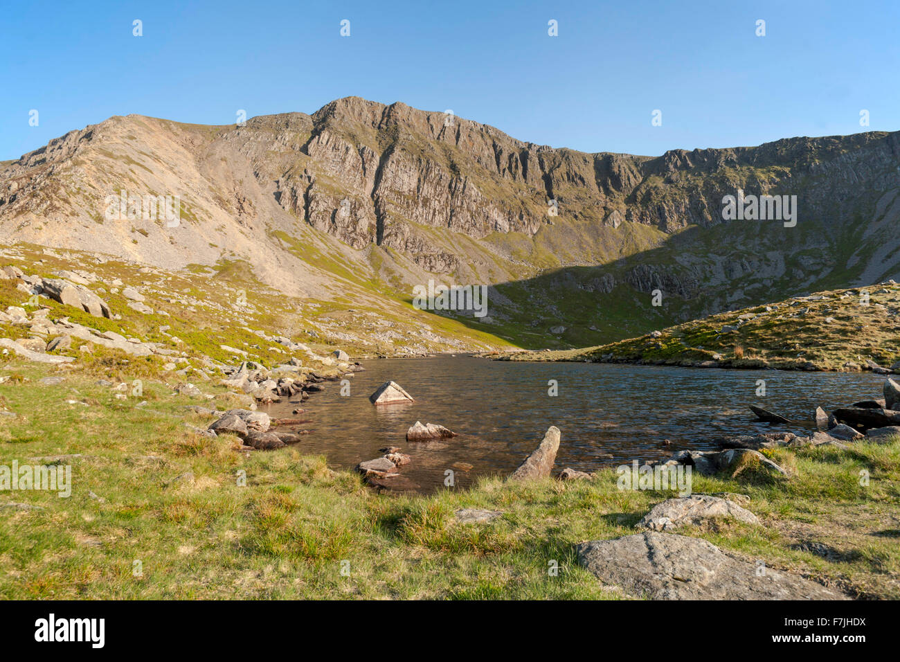 Ein kleiner Körper des Wassers am Fuße des Cader Idris Llyn y Gadair wird von Fox Weg erreicht. Ein kleiner See umgeben von Klippen, Stockfoto