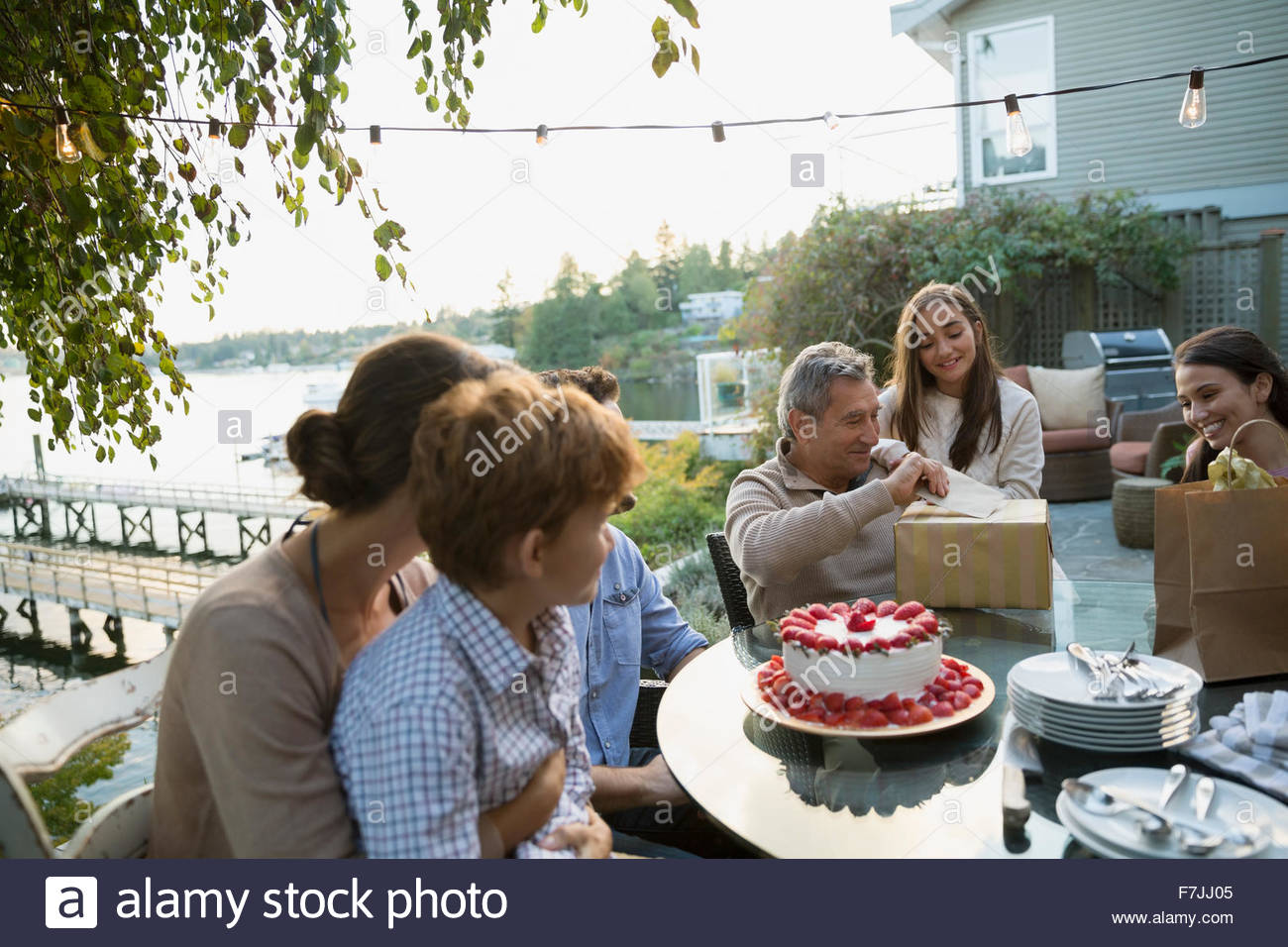 Senior woman Geburtstag Geschenke Familie am See Terrasse öffnen Stockfoto