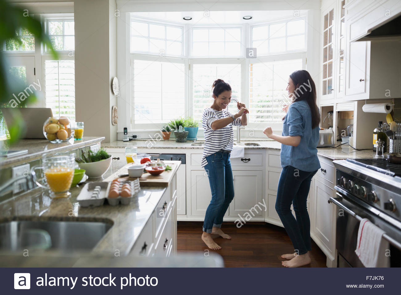 Mutter und Tochter tanzen in Küche Stockfoto