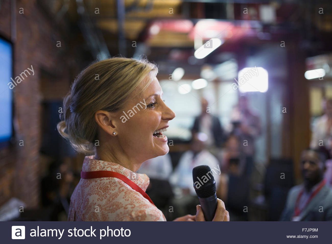 Geschäftsfrau mit Mikrofon auf Konferenz hautnah Stockfoto