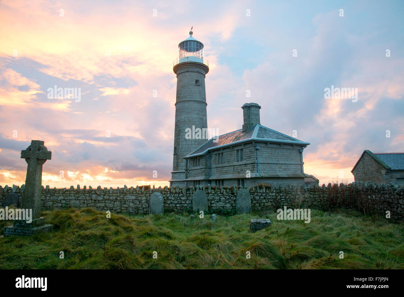 Lundy alte Licht, im Ruhestand Leuchtturm unter einen farbenfrohen Sonnenuntergang den Himmel Farben Schlüpflinge auf das Schieferdach Stockfoto