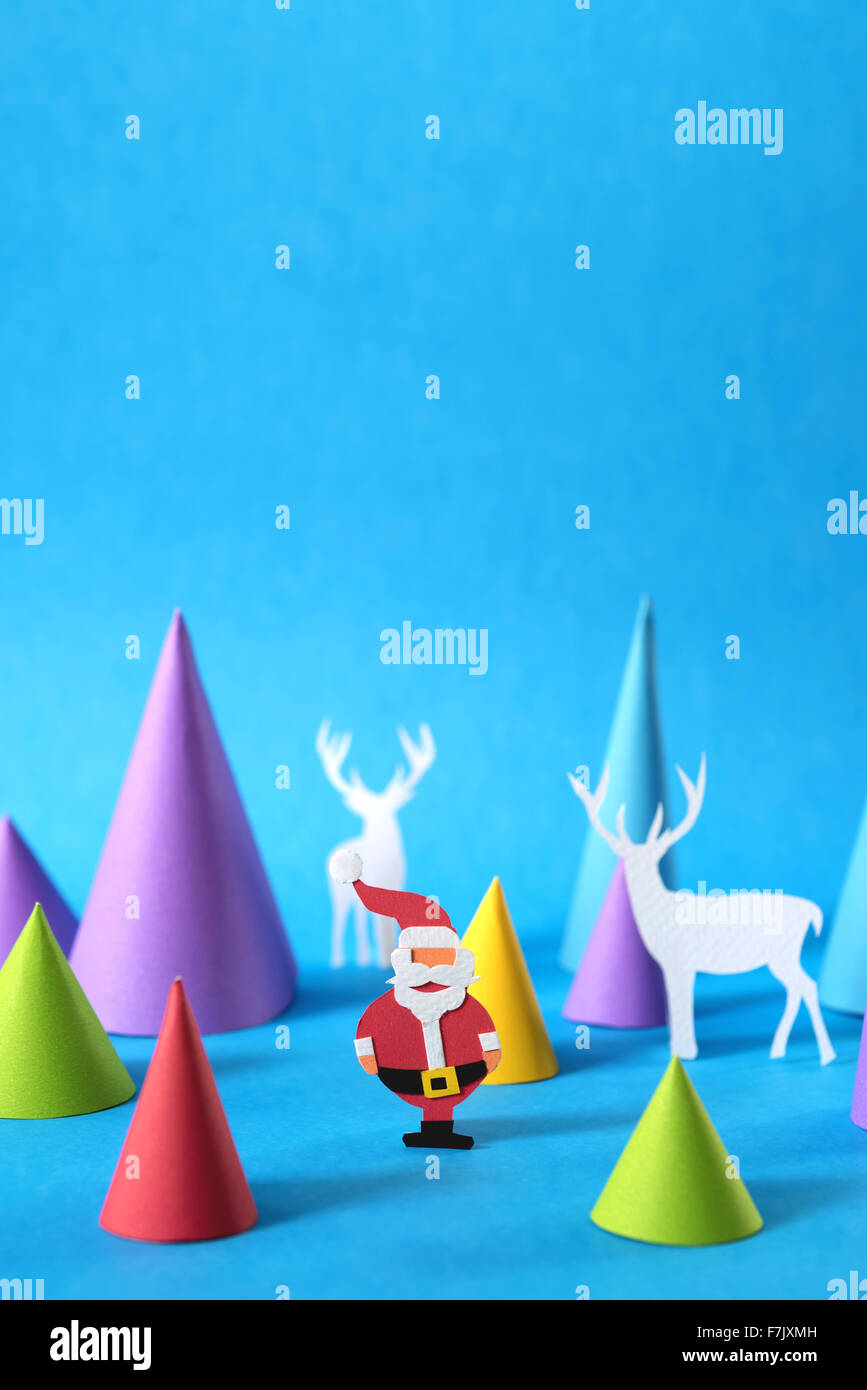 Farbiges Papier Handwerk Weihnachtsszene mit dem Weihnachtsmann, Hirsch Silhouetten und Xmas Kiefer Baum Formen umfasst Textfreiraum. Stockfoto