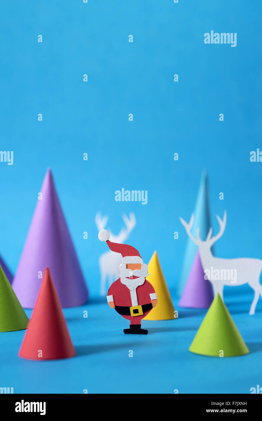 Weihnachtsszene mit handgeschöpftem Papier Santa, Hirsche und Kiefer Baum Schnittformen, Textfreiraum enthält. Ideal für Urlaub Grußkarte Stockfoto