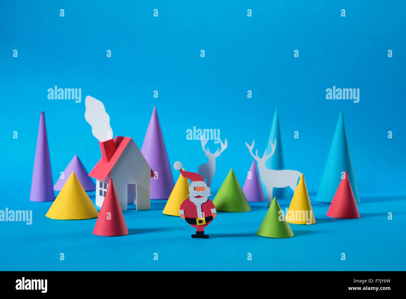 Weihnachtszeit: handgeschöpftes Papier Schneiden Santa vor Haus mit Kiefer Baum Formen und Hirsche. Ideal Weihnachts-Grußkarte, Urlaub Plakat Stockfoto