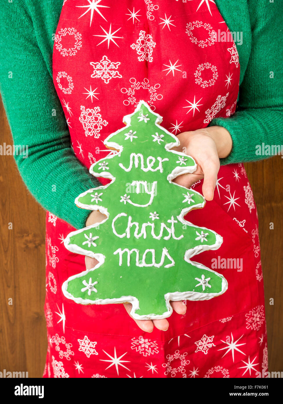 Eben mit hausgemachten Weihnachtsbaum-wie Lebkuchen mit grüner Glasur und Frohe Weihnachten schreiben Stockfoto
