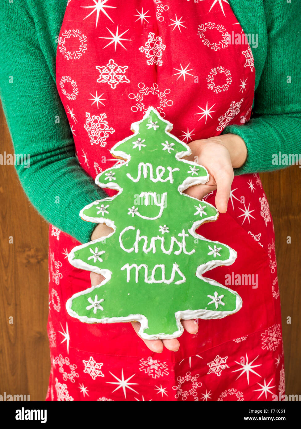 Eben mit hausgemachten Weihnachtsbaum-wie Lebkuchen mit grüner Glasur und Frohe Weihnachten schreiben Stockfoto