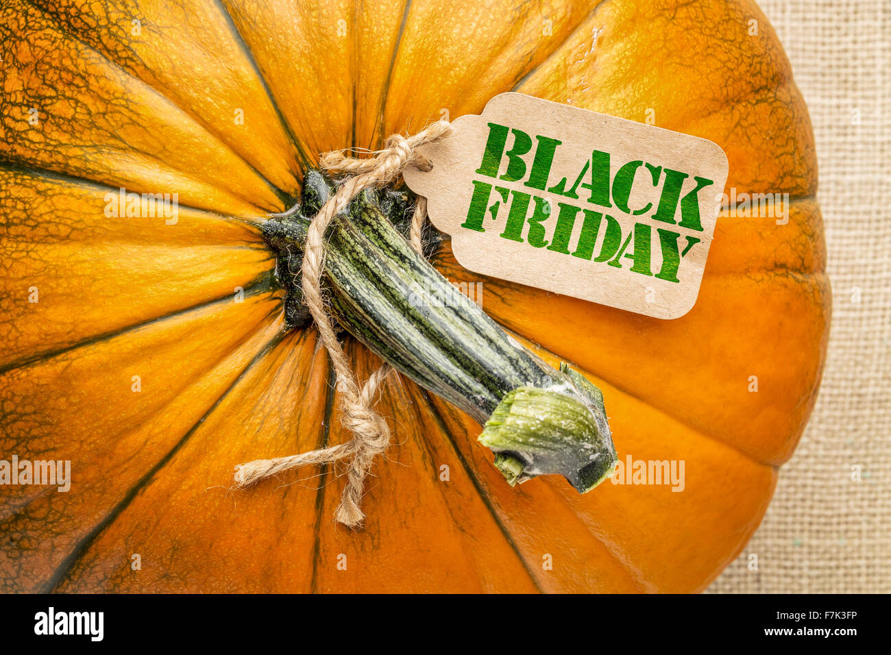 Schwarzer Freitag-Preisschild auf einem Kürbis gegen Sackleinen Leinwand Stockfoto