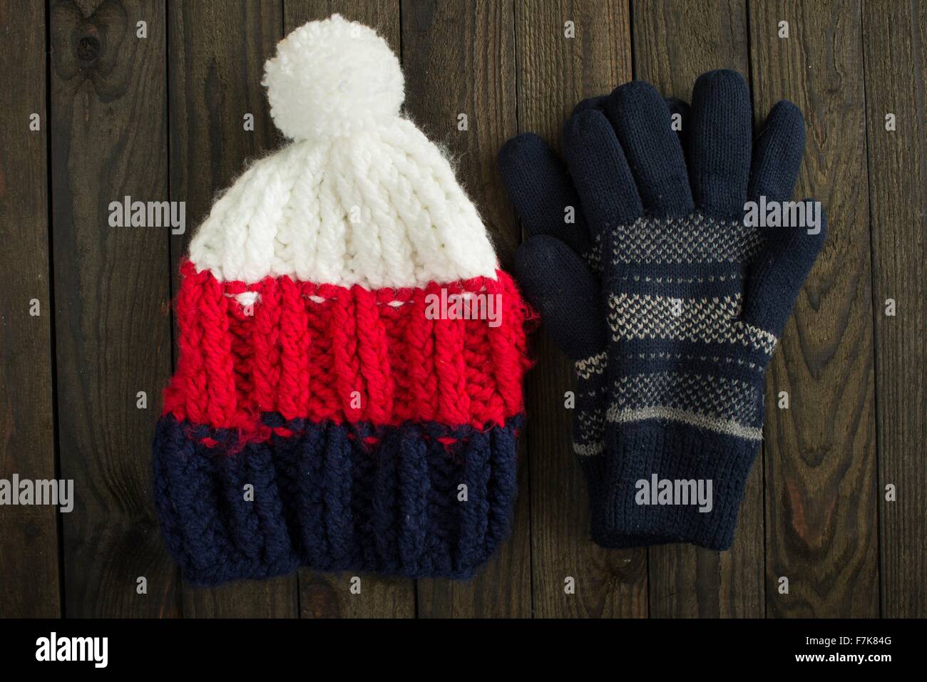 Wintermütze und Handschuhe auf hölzernen Hintergrund Stockfoto