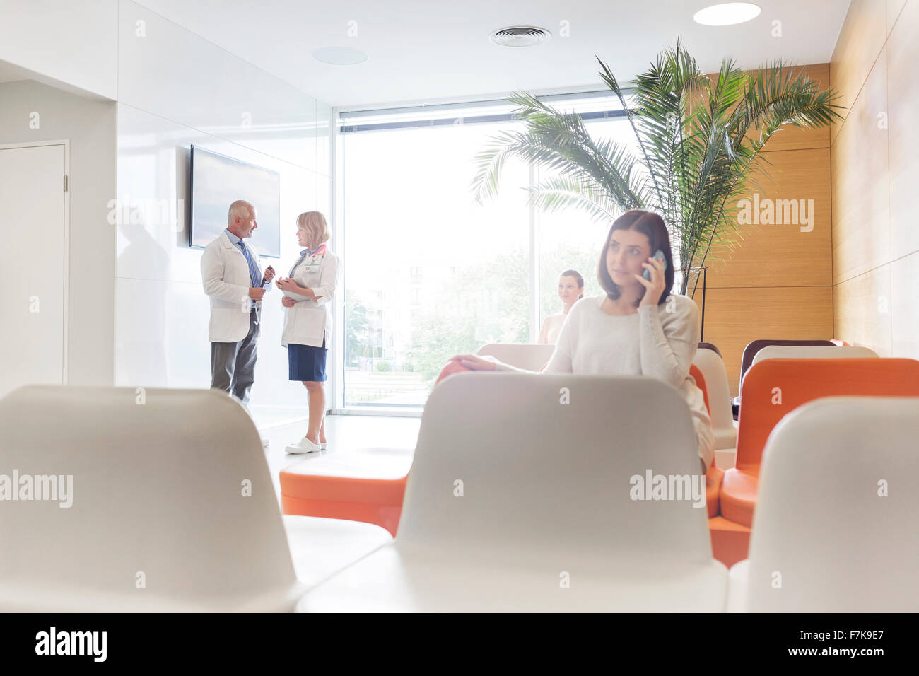 Frau am Handy im Krankenhaus lobby Stockfoto