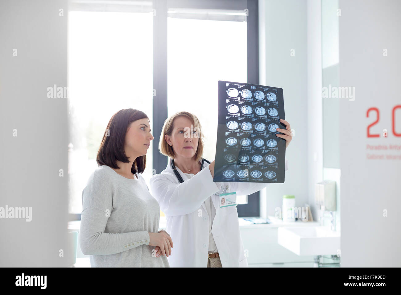 Ernst Arzt und Patient, die Überprüfung der Röntgenstrahlen im Untersuchungsraum Stockfoto