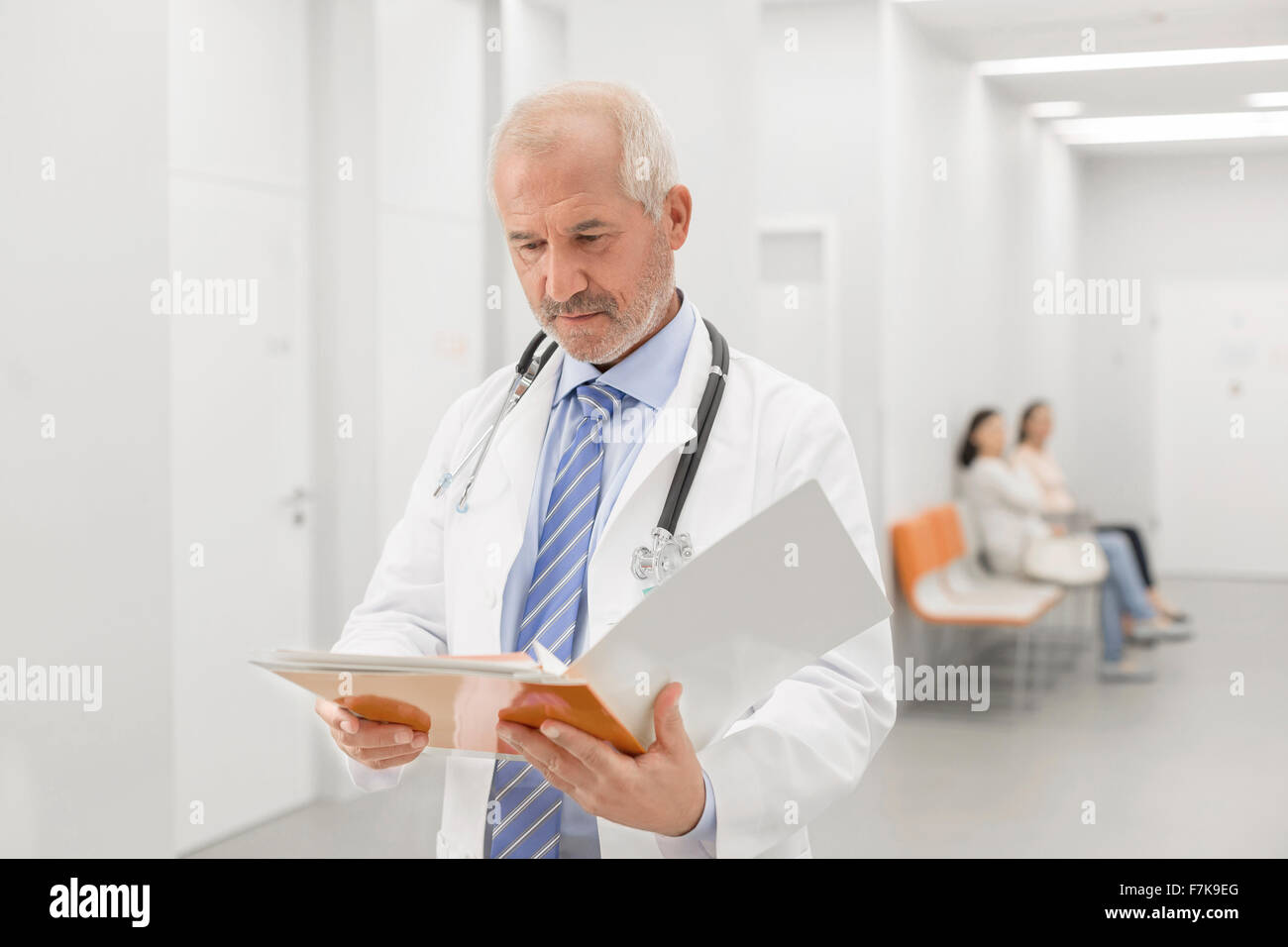 Arzt machen runden Krankenakte im Krankenhausflur überprüfen Stockfoto