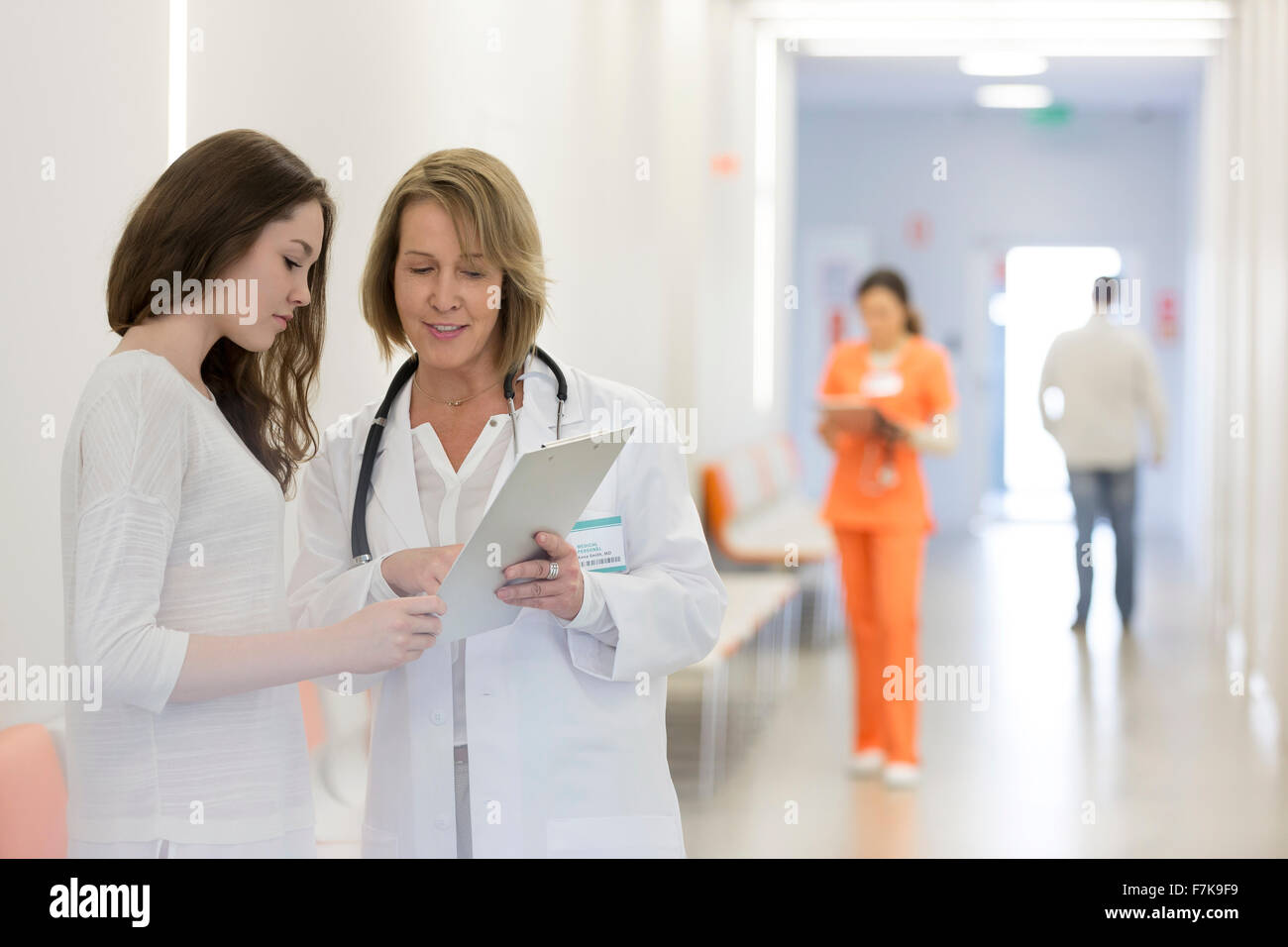 Arzt und Patient, die Überprüfung der Krankenakte im Krankenhausflur Stockfoto