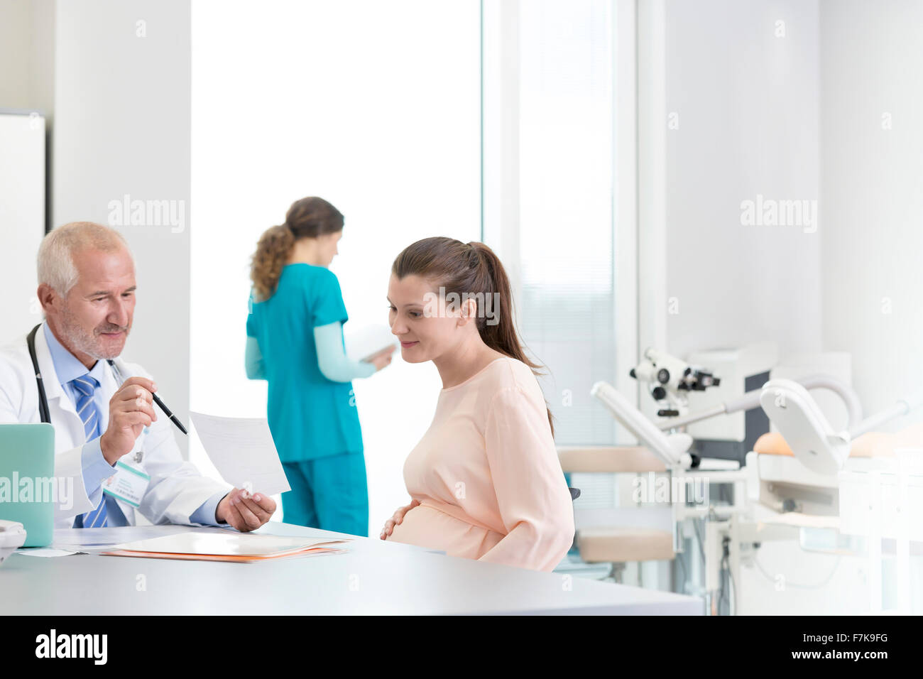 Arzt und Schwangere Patienten diskutieren Rezept in Klinik Stockfoto