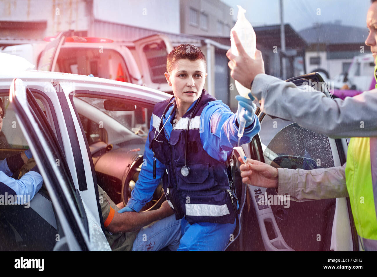 Rettungskräfte mit IV Tasche tendenziell Auto Unfallopfer Stockfoto