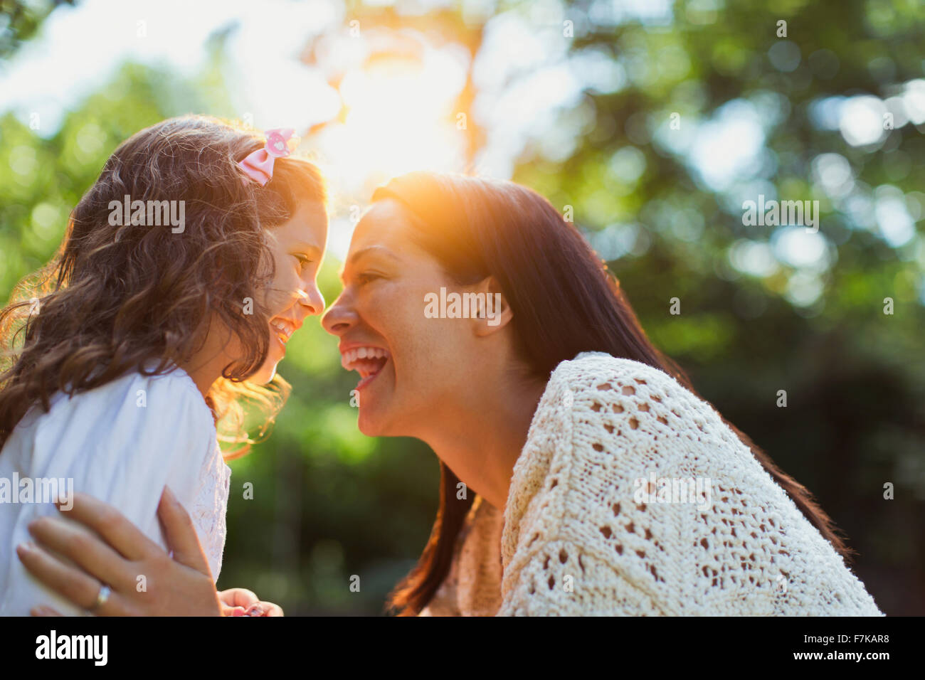 Begeisterte Mutter und Tochter lächelnd von Angesicht zu Angesicht Stockfoto