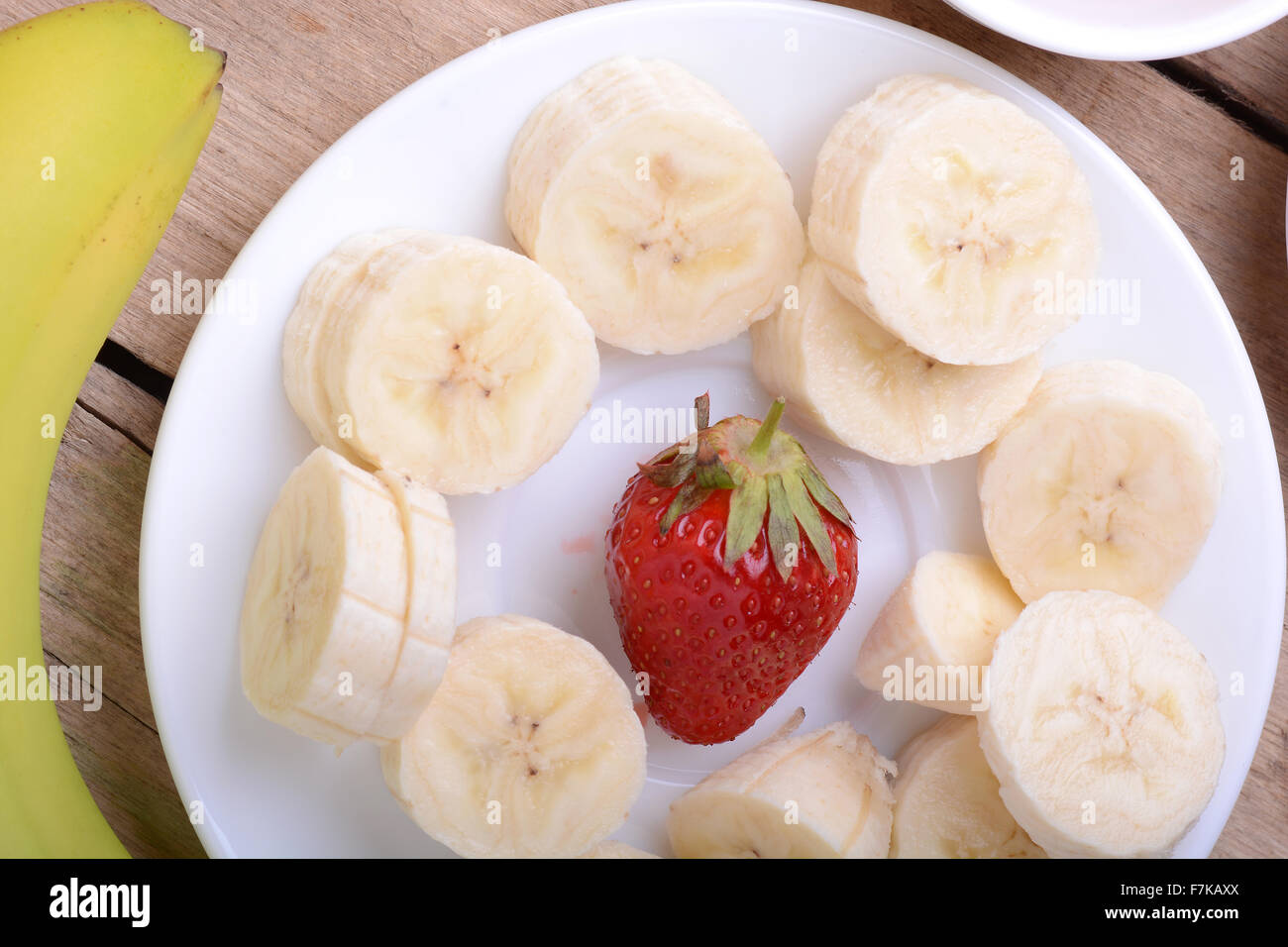 gesunde Erdbeeren und Bananen Scheiben auf hölzernen Hintergrund Stockfoto