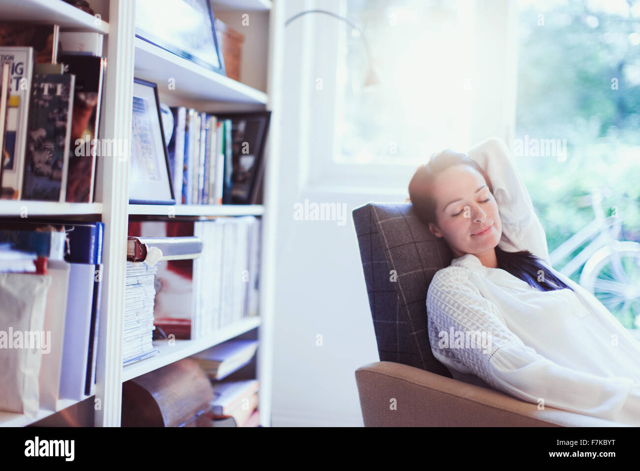 Gelassene Frau Nickerchen im Sessel Stockfoto