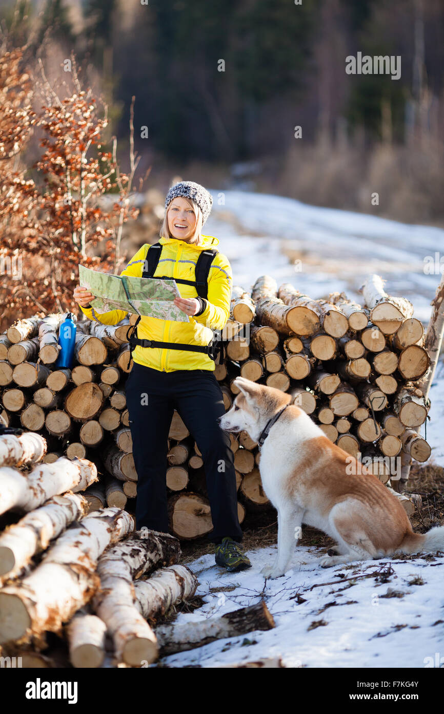 Frau im Wald wandern und lesen Karte mit Hund camping. Erholung und einen gesunden Lebensstil im Freien in der Natur. Stockfoto