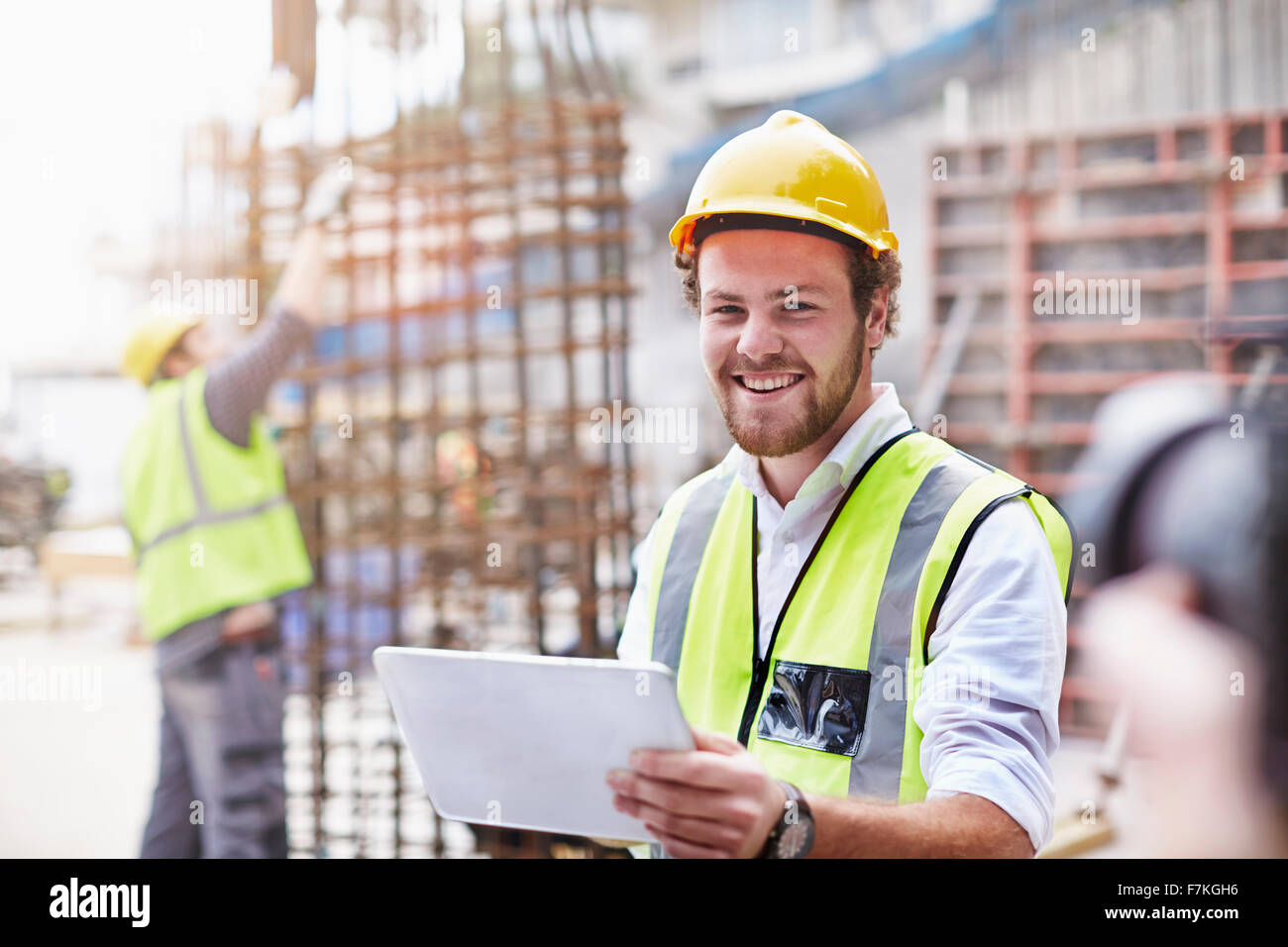 Porträt zuversichtlich Bauarbeiter mit digital-Tablette auf Baustelle Stockfoto