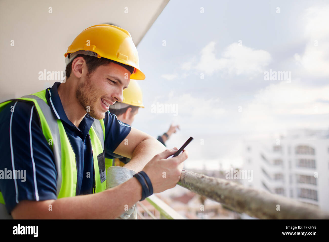 Bau Arbeiter SMS auf Hochhaus-Baustelle Stockfoto